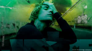 A Man With Green Hair Is Holding His Head Up Wallpaper