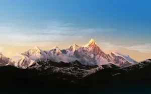 A Mountain Range With Snow Capped Mountains In The Background Wallpaper