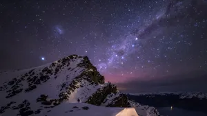A Mountain With Snow And Stars Above It Wallpaper