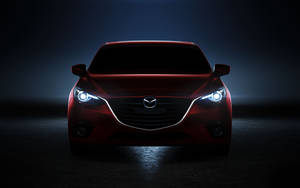 A Neon Red Mazda 2 Illuminated In Nightfall Wallpaper