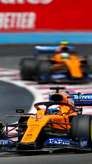 A Orange And Blue Racing Car On A Track Wallpaper
