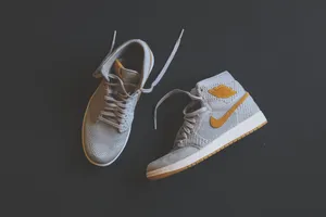 A Pair Of Air Jordan 1 High Sneakers On A Black Surface Wallpaper