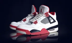 A Pair Of White And Red Air Jordan 4 Sneakers Wallpaper