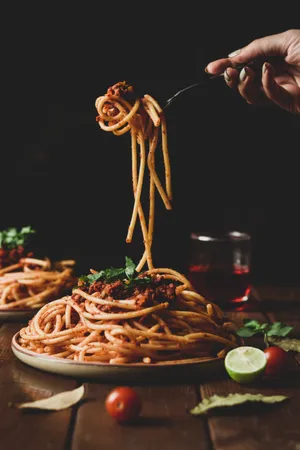 A Person Is Holding Spaghetti On A Plate Wallpaper