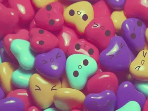 A Pile Of Colorful Candy Hearts With Faces Wallpaper