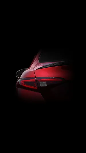 A Powerful, Sleek Red Car Against A Bright Blue Sky. Wallpaper