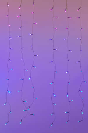 A Purple And Blue Light String Hanging From A Purple Wall Wallpaper