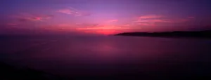 A Purple Sunset Over The Ocean Wallpaper