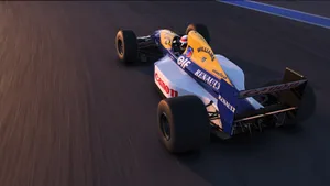 A Racing Car Driving Down A Track Wallpaper