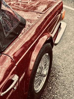 A Red Car With Chrome Logo Wallpaper