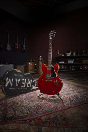 A Red Guitar Is Sitting On A Rug In A Room Wallpaper