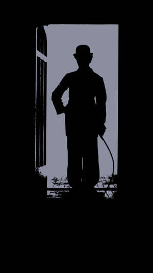 A Silhouette Of Charlie Chaplin In Front Of A Door Wallpaper