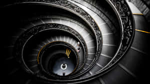 A Spiral Staircase With A Person On It Wallpaper