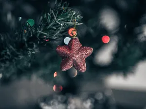 A Star-lit Christmas Tree Shines Brightly Against A Dark Night. Wallpaper