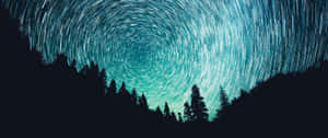 A Star Trail Over A Forest Wallpaper