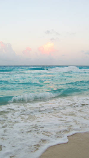 A Stunning Ocean Wave Overlooking A Beautiful Beach. Wallpaper