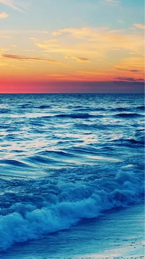 A Sunset Over The Ocean With Waves Wallpaper