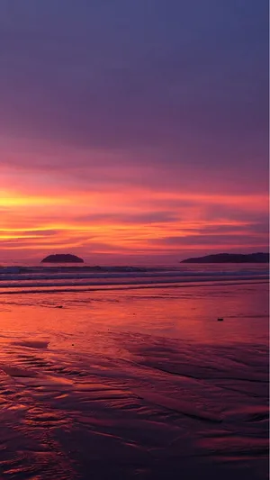 A Tranquil Sunset View Of The Beach On An Iphone Wallpaper