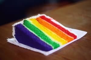 A Vibrant Gay Pride Celebration Symbolized By A Rainbow-layered Cake Wallpaper