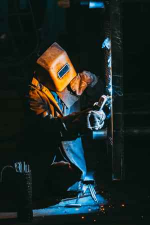 A Welder Working On A Metal Piece Wallpaper