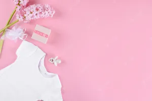A White Baby Bodysuit On Pink Background With Flowers Wallpaper