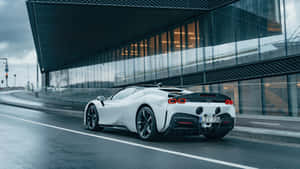 A White Sports Car Driving Down A Street Wallpaper