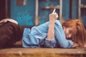 A Woman Laying On The Ground With Her Cigarette Wallpaper