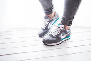A Woman Wearing A Pair Of Sneakers Wallpaper