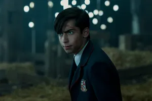 A Young Man In A School Uniform Standing In A Barn Wallpaper