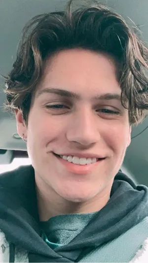 A Young Man Smiling In A Car Wallpaper