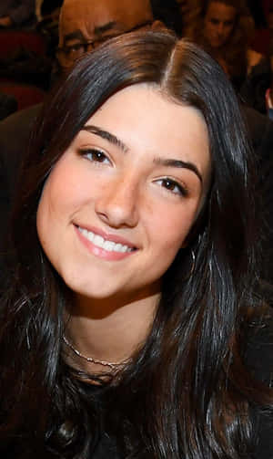 A Young Woman With Long Black Hair Smiling Wallpaper