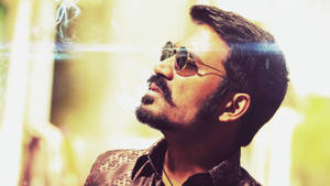 Action Star Dhanush Blowing Smoke Wallpaper