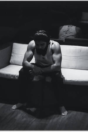 Adithya Varma Contemplating Alone On Couch Wallpaper