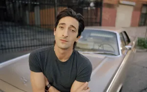 Adrien Brody On A Vintage Car Wallpaper