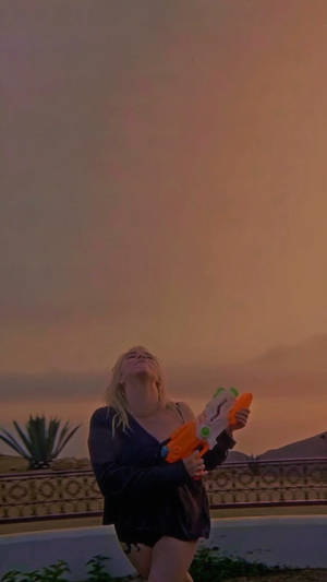 Aesthetic Billie Eilish With Water Gun Wallpaper