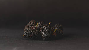 Aesthetic Black Mulberry Fruits On Black Wallpaper