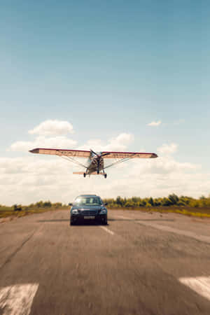 Airplane Landing Above Car Wallpaper