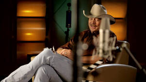 Alan Jackson On Brown Leather Chair Wallpaper