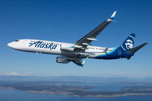 Alaska Airlines Soaring Above The Sea Wallpaper