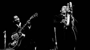 American Saxophonist John Coltrane And Guitarist Wes Montgomery Wallpaper