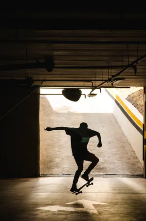 An Adventurous Street Skater Making A Daring Jump Over An Obstacle Wallpaper