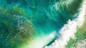 An Aerial View Of A Green Wave In The Ocean Wallpaper