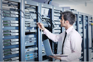 An Expert Technician Working On Data Server Racks Wallpaper