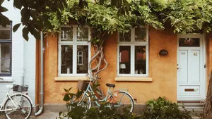 An Orange House With A Lush Green Surrounding Wallpaper
