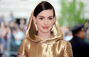 Anne Hathaway In A Glamorous Golden Robe Wallpaper