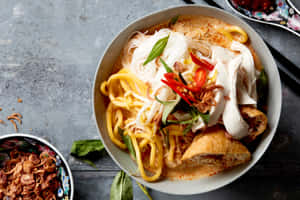 Aromatic And Spicy Curry Laksa With Diverse Garnishes Wallpaper