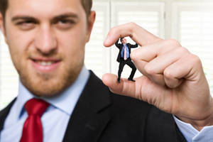 Arrogant Businessman Squishing Tiny Co-worker Wallpaper