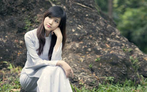 Asian Women Sitting By A Rock Wallpaper