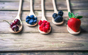 Assorted Berries On Wooden Spatulas Wallpaper