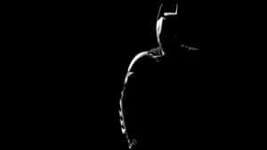 Batman In The Dark Silhouetted Against A Black Background Wallpaper